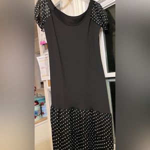 Black dress with sheer black and white polka dot sleeves and asymmetrical skirt
